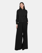 alt
Model wearing LEEZZA OZAI N KÜ GALA black wide-leg trousers with front overlap detail and side pockets
