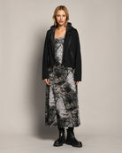 LEEZZA model wearing an AMBER & MOON DORA long jacquard jersey dress with a subtle print and a black hooded jacket.