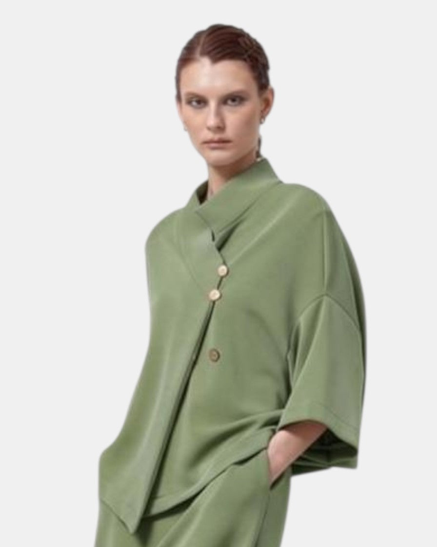 LEEZZA model wearing a sage green LOTUS EATERS AGONION oversized modal jersey vest with an asymmetrical button closure.